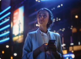 Joven usando su celular en una ciudad con luces nocturnas