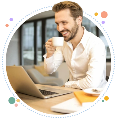 Hombre trabajando en su notebook, sonriendo mientras toma café