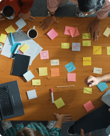 Reunión de equipo con mesa llena de notas adhesivas para organizar ideas